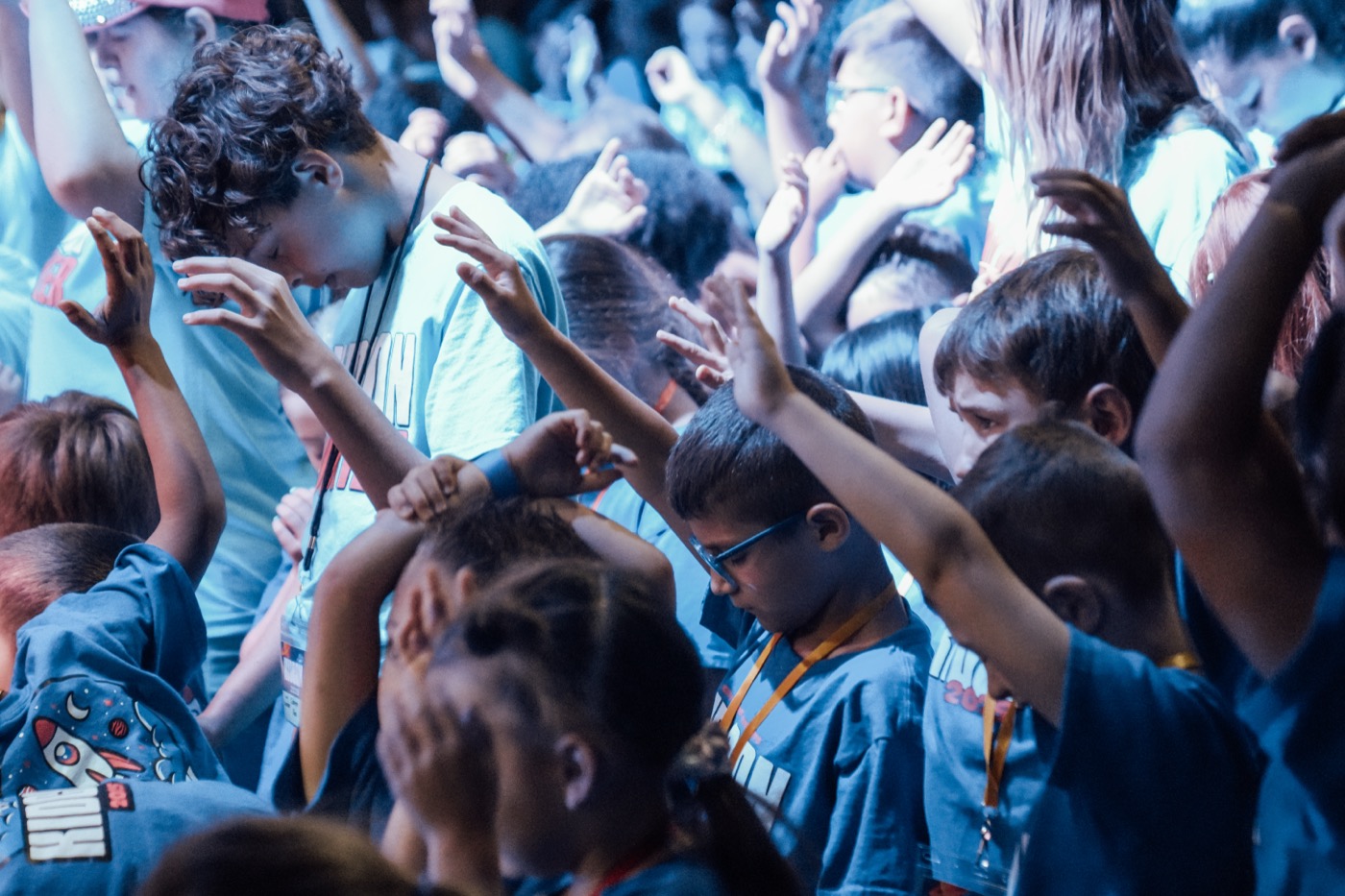 Kids worshipping with hands raised at KidCon