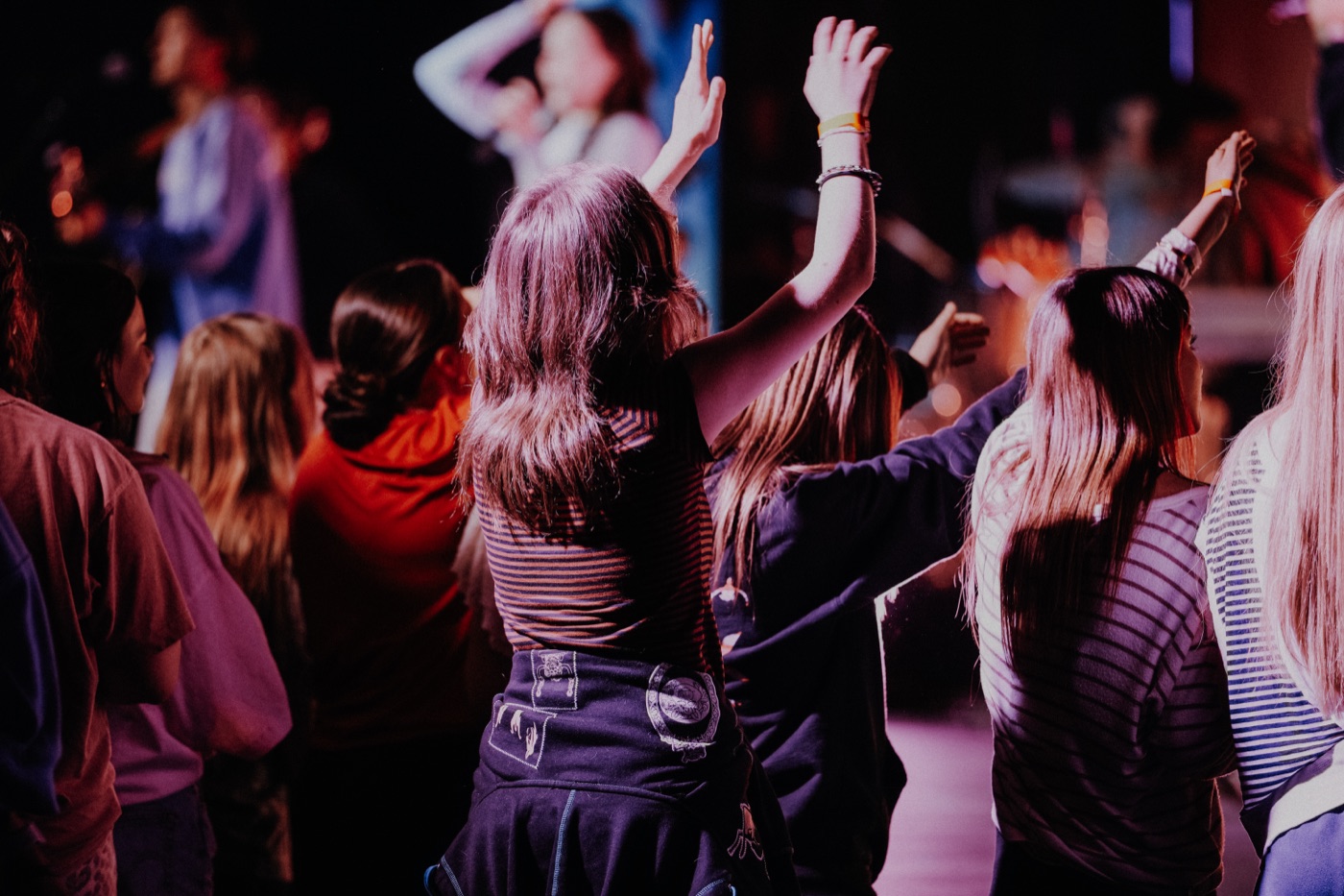 Students worshipping with hands raised at CYC