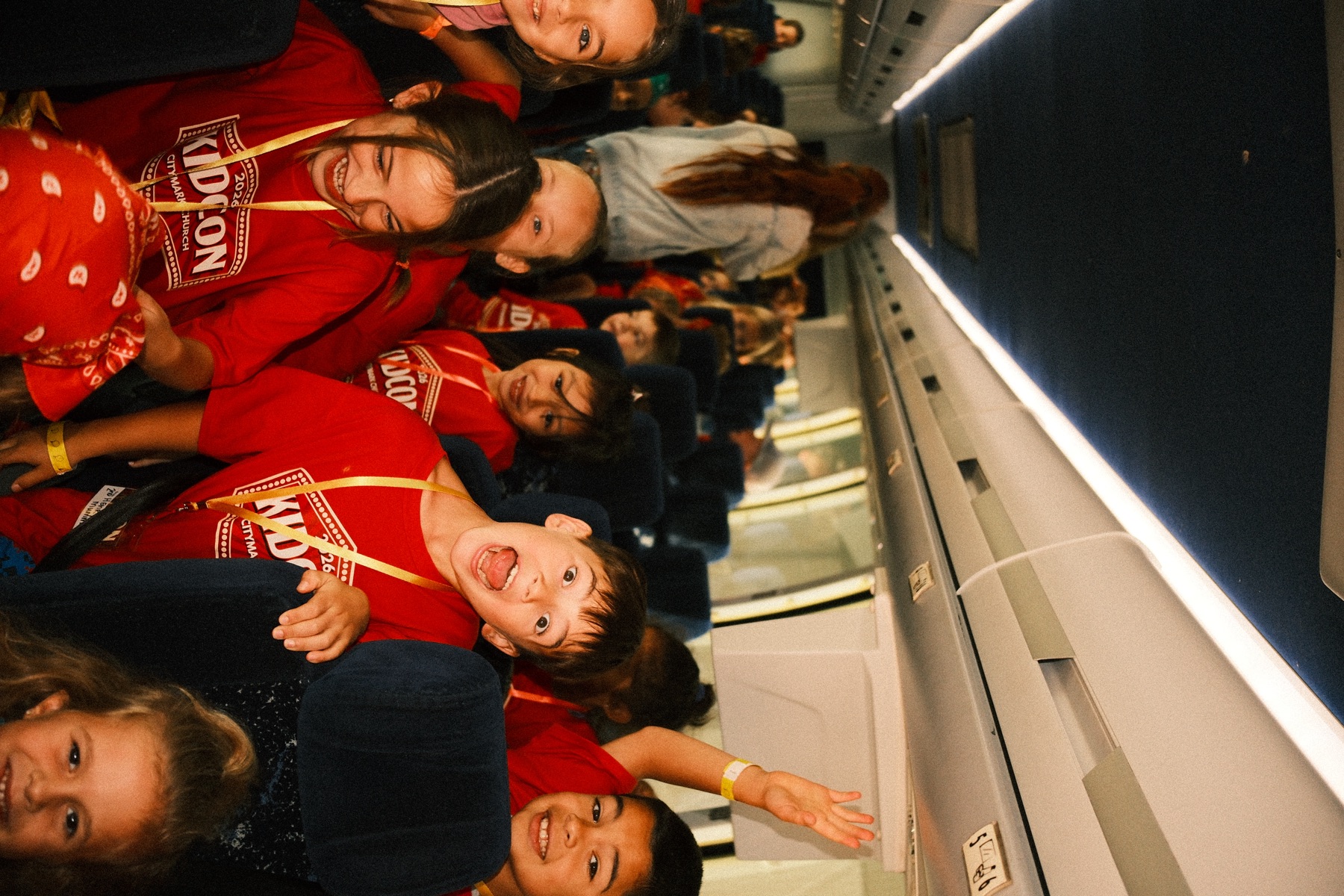 Kids laughing on the charter bus to a KidCon off-site adventure